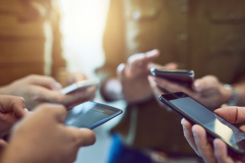 Grupo de personas utilizando smartphones en sincronía